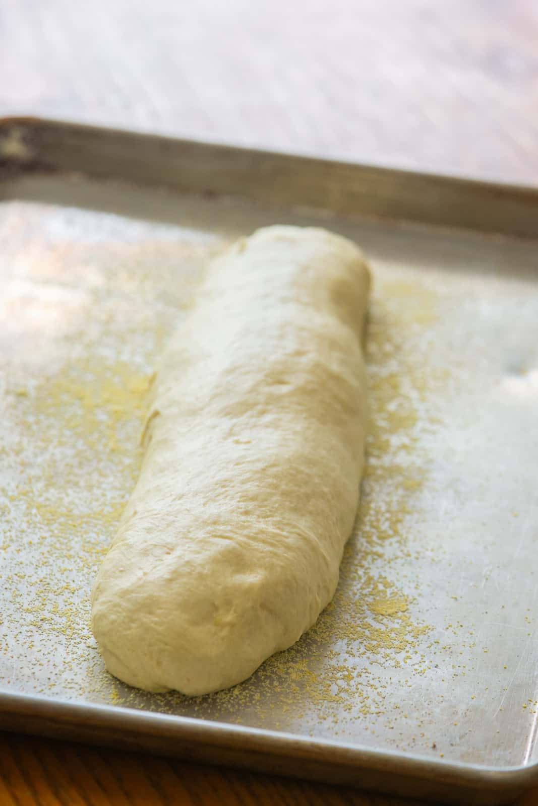 Loaf of French bread dough rising on pan