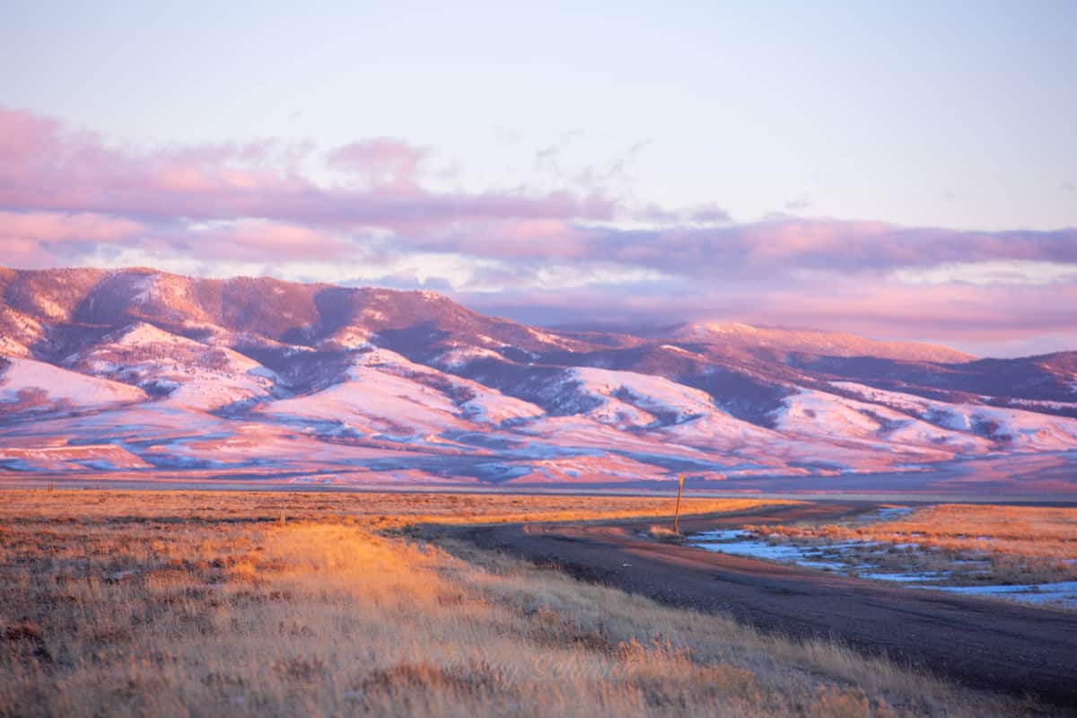 snowy mountains near a dirt road
