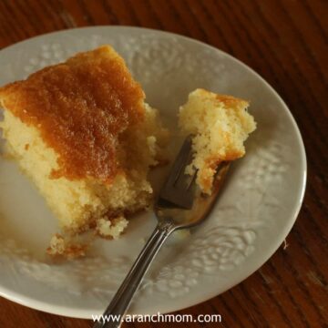 Yellow cake slice on plate.