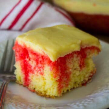 square of yellow cake with red jello streaks and pudding on top.