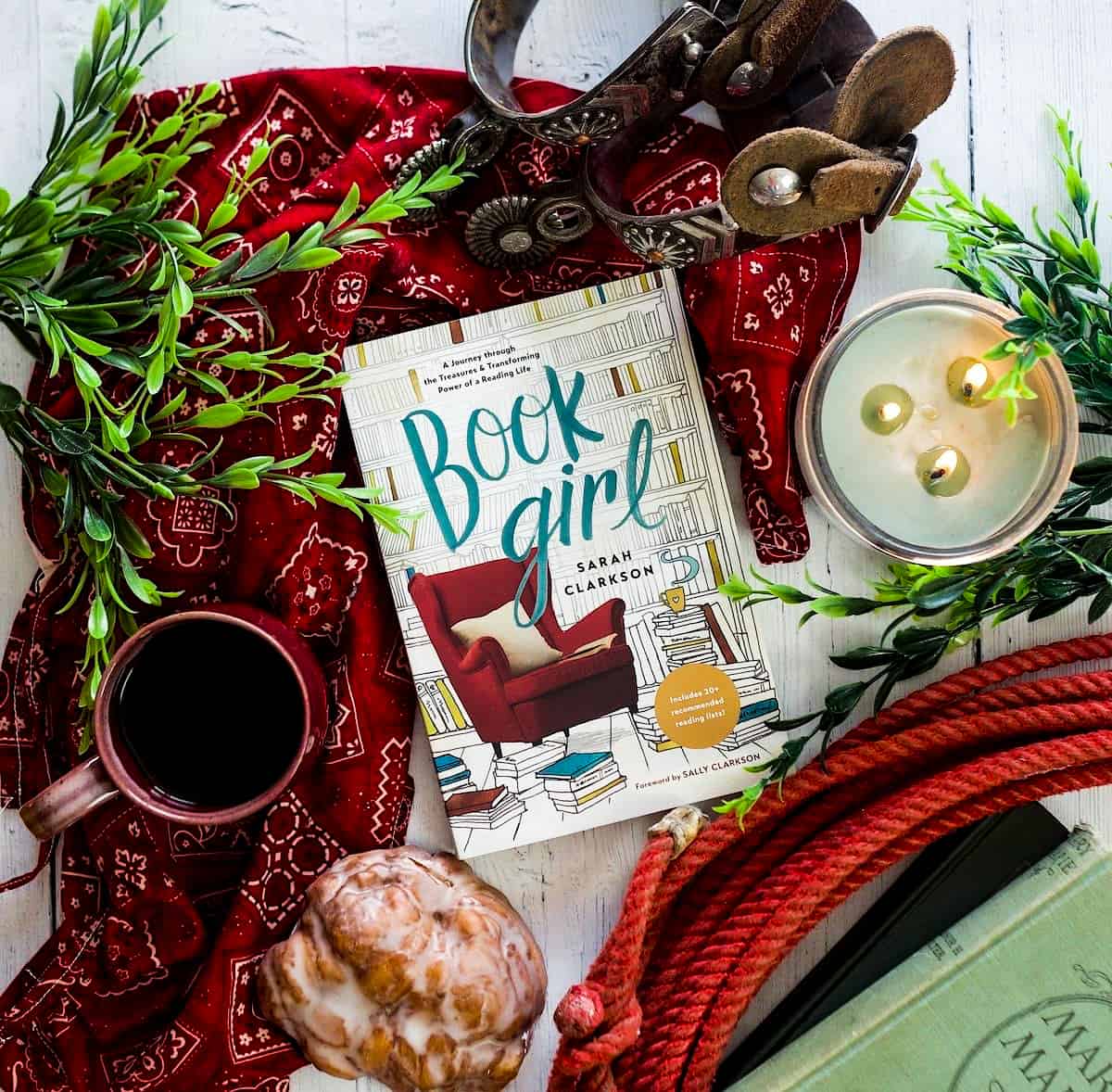 themed book photo, book, mug, candle, and pastry on a cloth