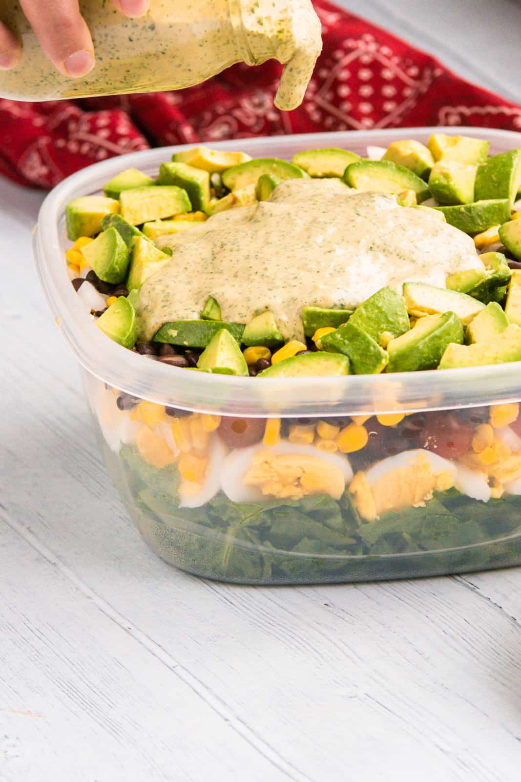 Pouring salad dressing on top of salad