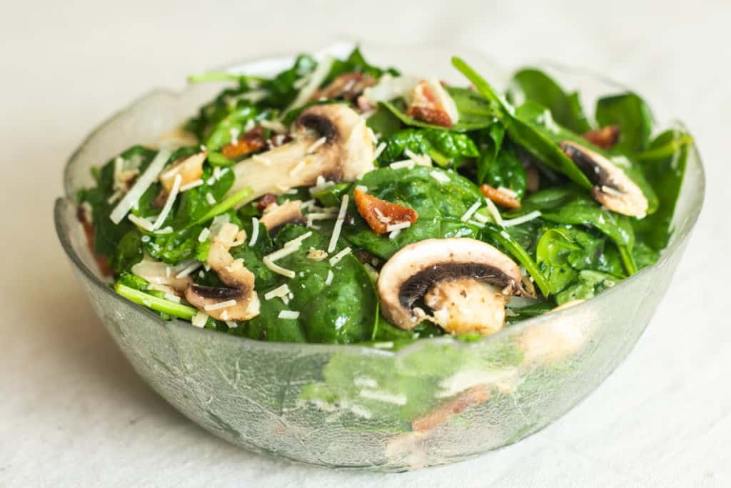 spinach mushroom salad in glass bowl