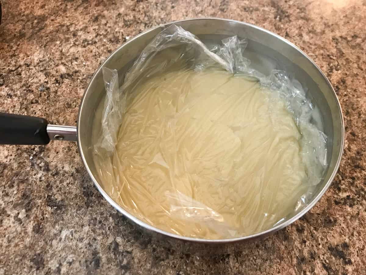 pan of dairy free vanilla pudding with plastic on top