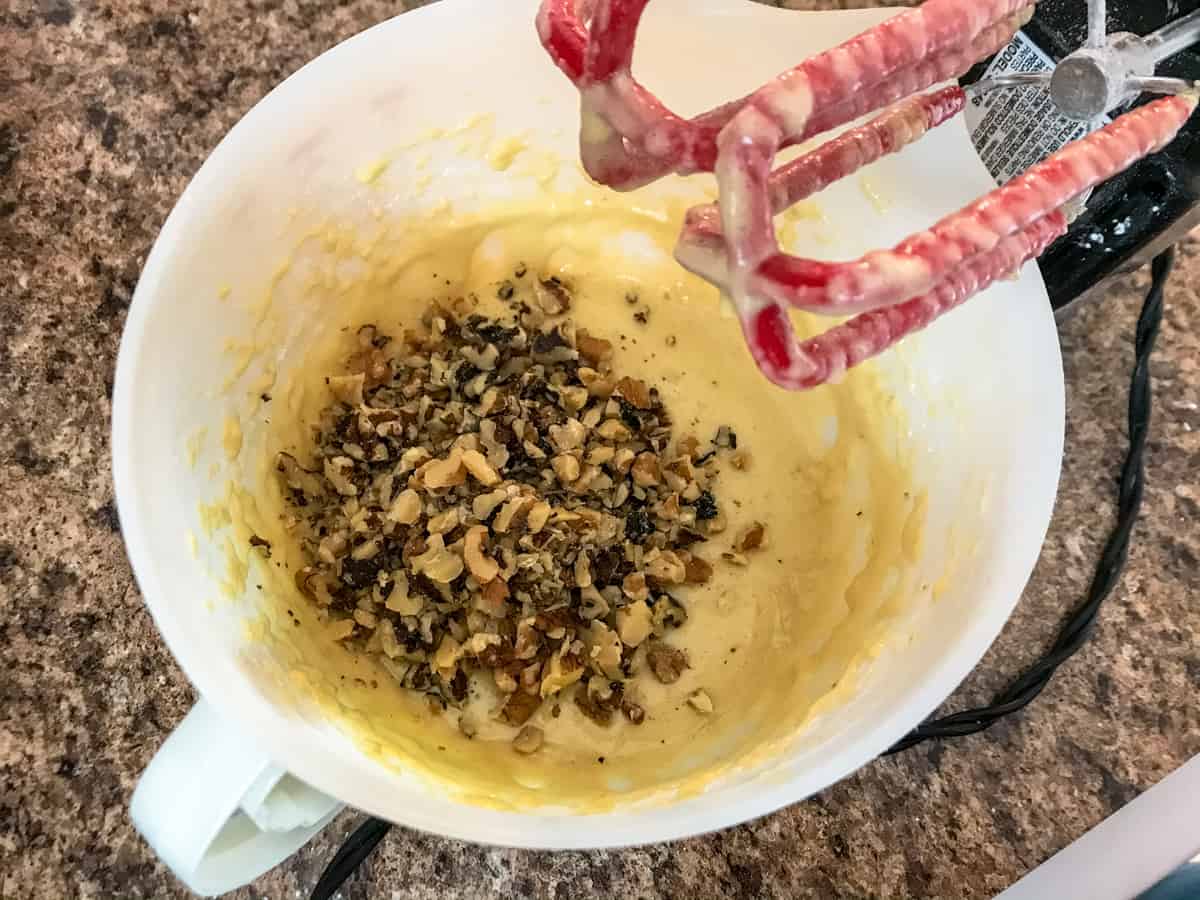 chopped nuts in bowl of bread batter