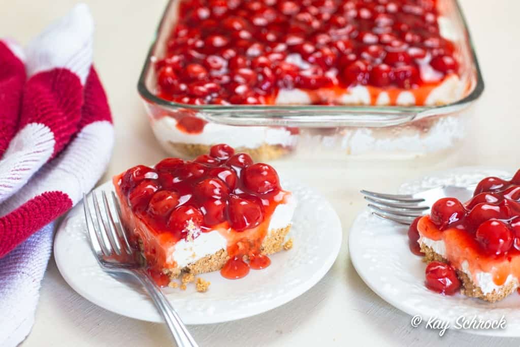 dwa kawałki deseru cherry delight na spodkach z patelnią w tle