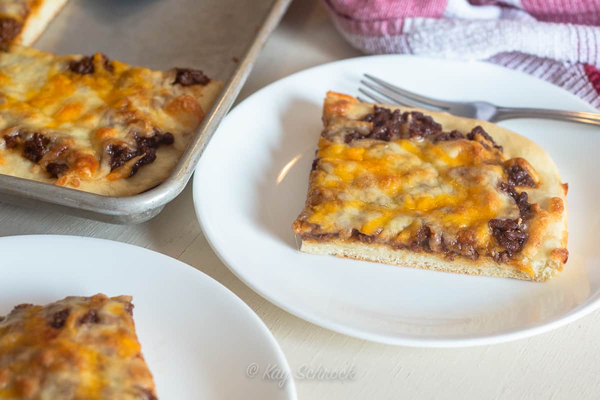 white plate with slice of bbq beef pizza 
