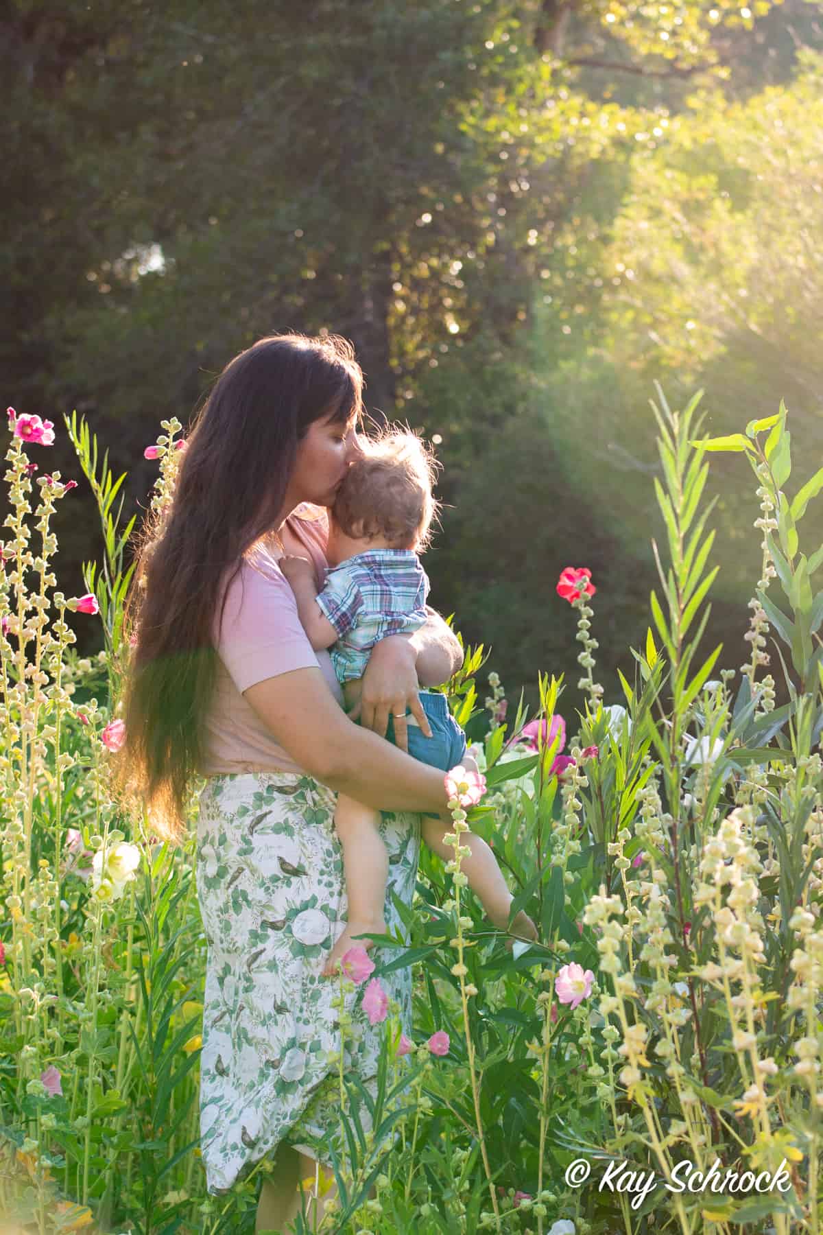 mom holding toddler in flower garden