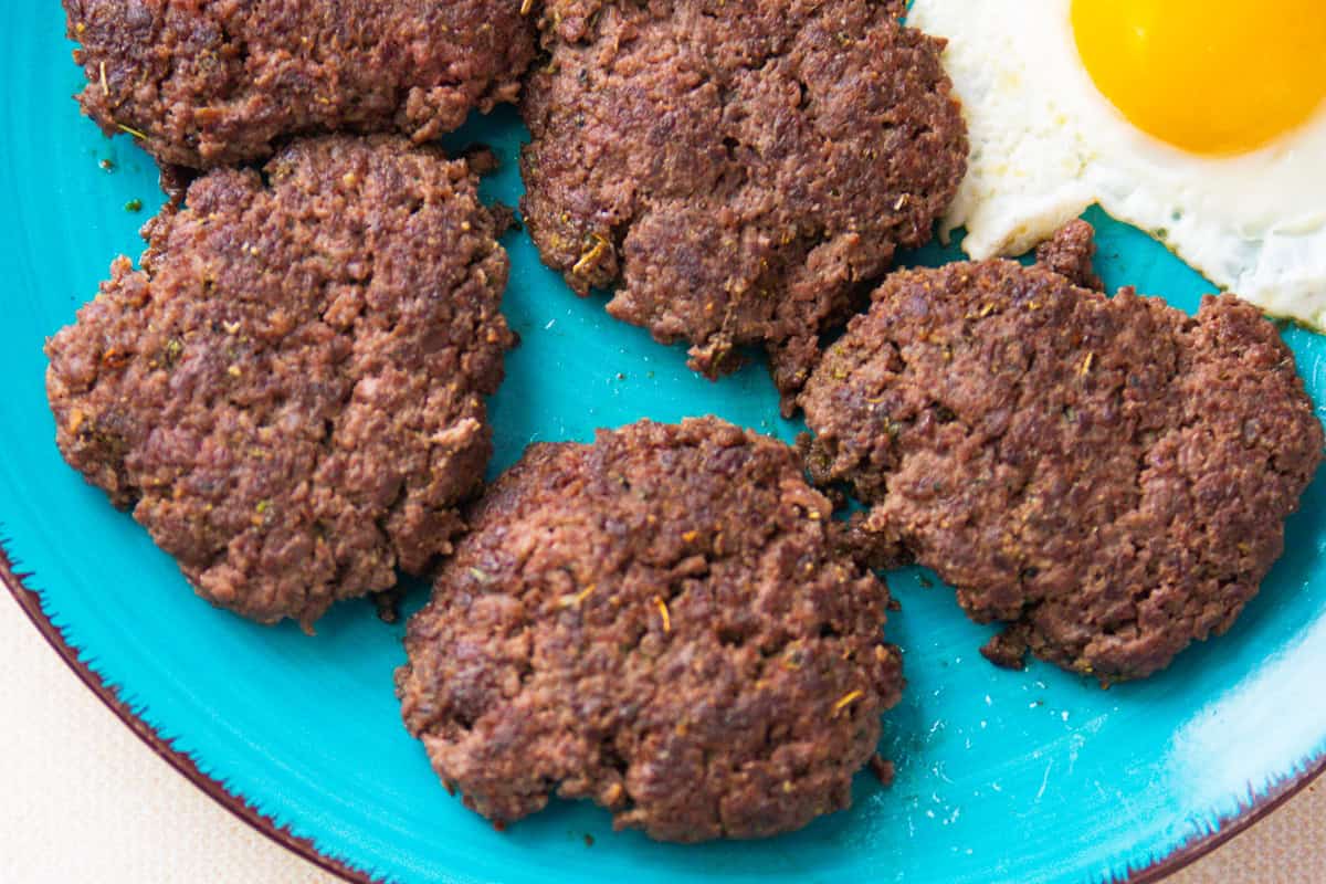 Venison sausage patties on a blue plate