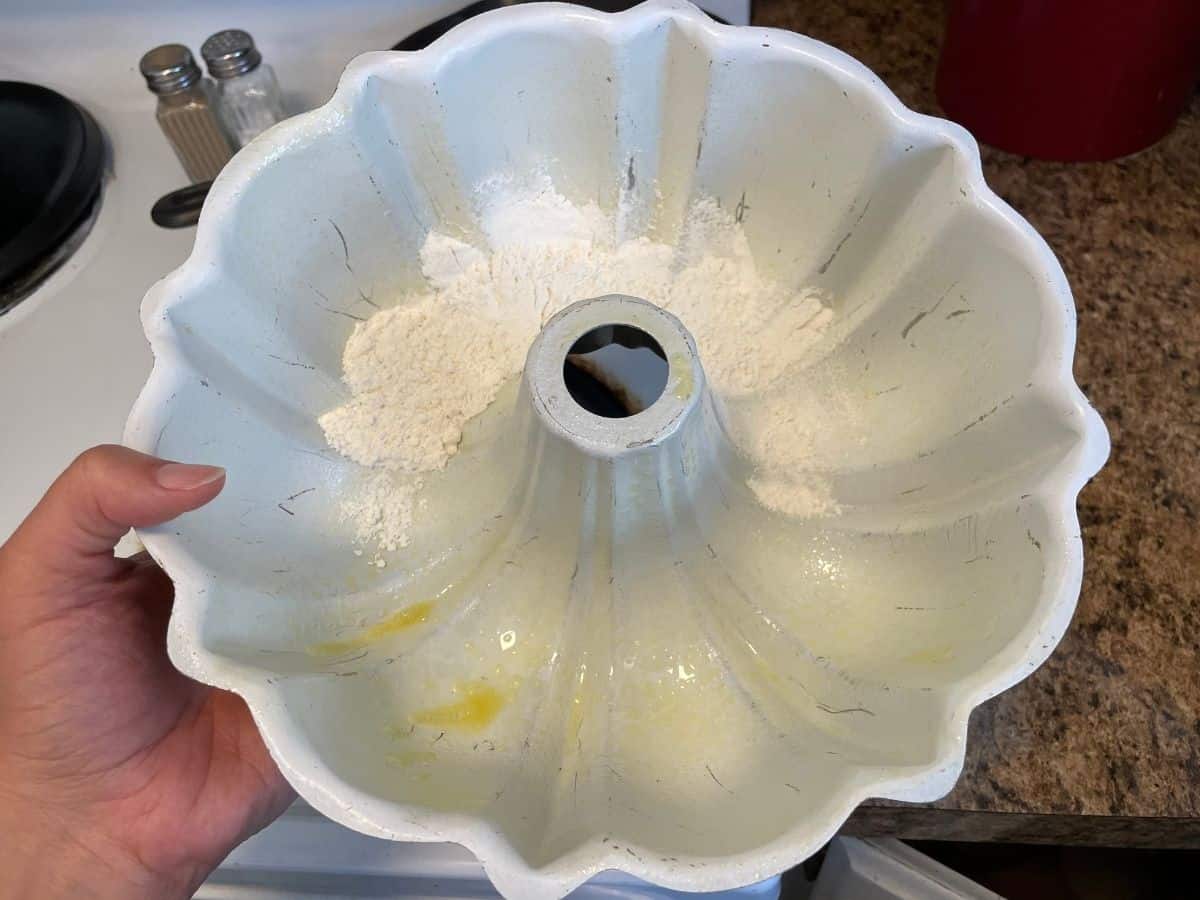 flouring a greased bundt cake pan