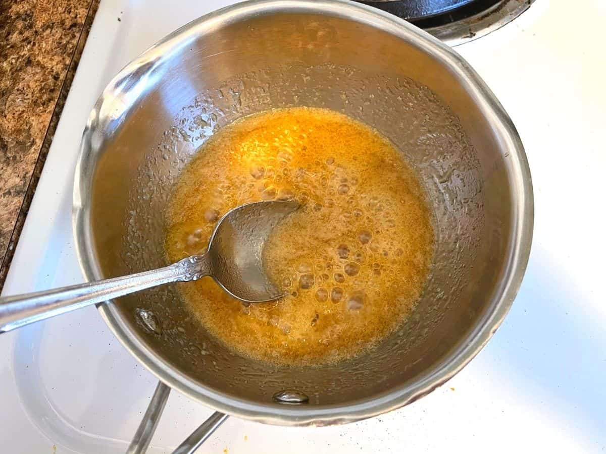 homemade caramel sauce bubbling in pan on stove