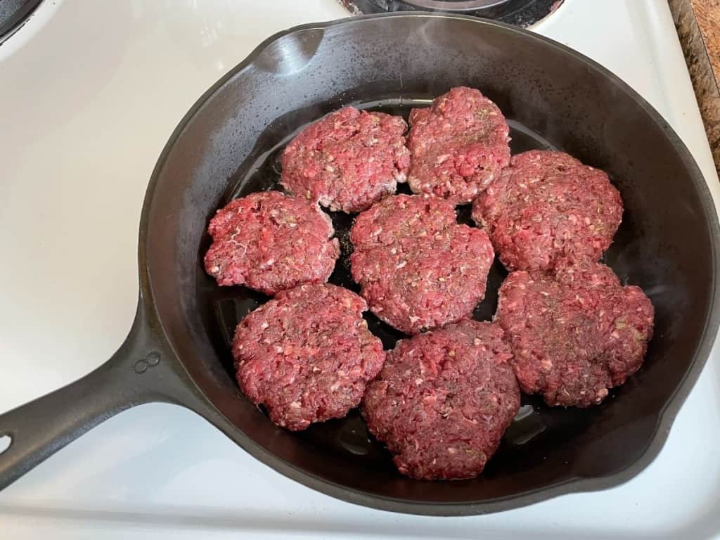 raw deer sausage in a cast iron frying pan