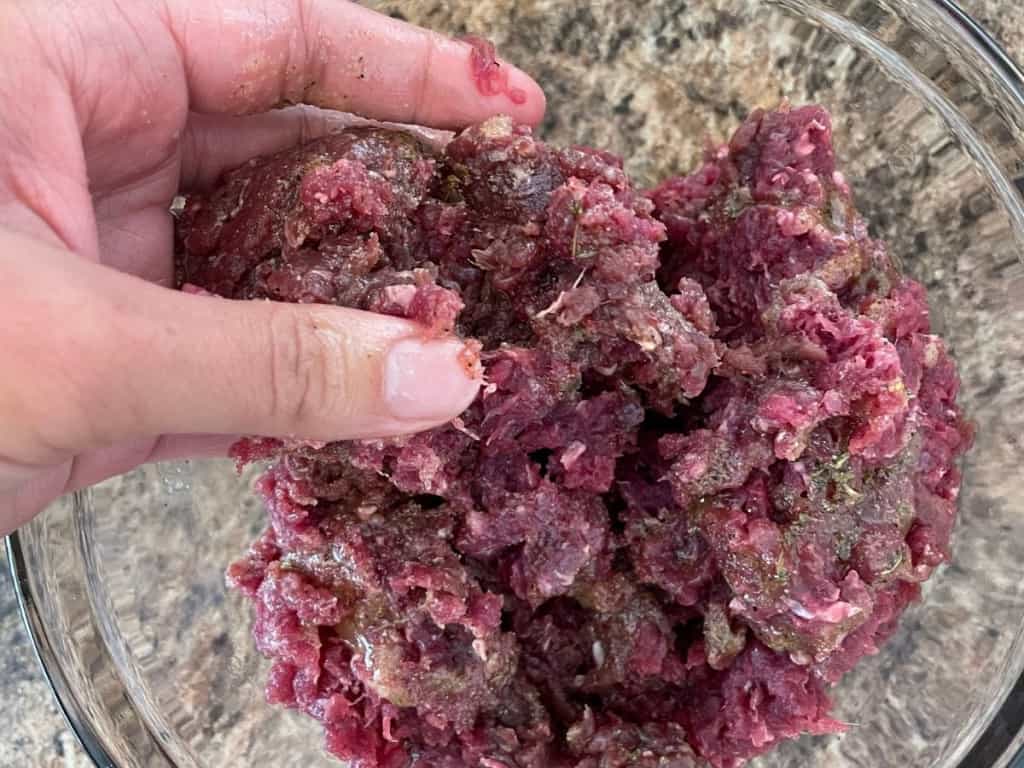 venison sausage being mixed with fingers