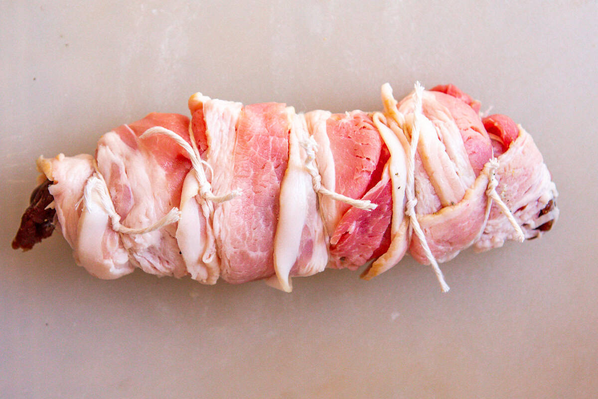 deer tenderloin, stuffed and wrapped in bacon, tied with string.