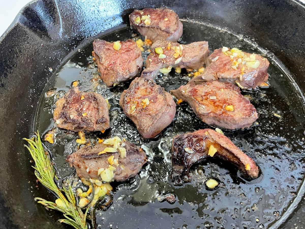 deer backstrap searing in cast iron pan with butter
