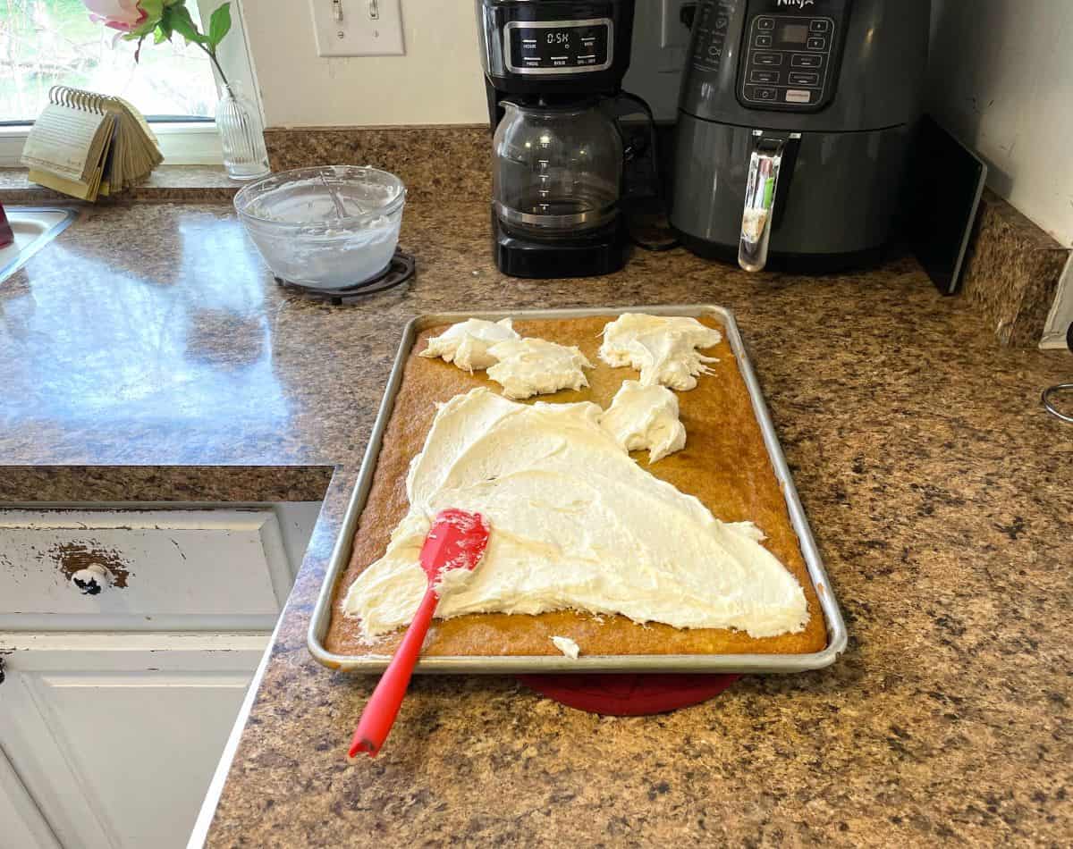 red spatula spreading frosting on bars