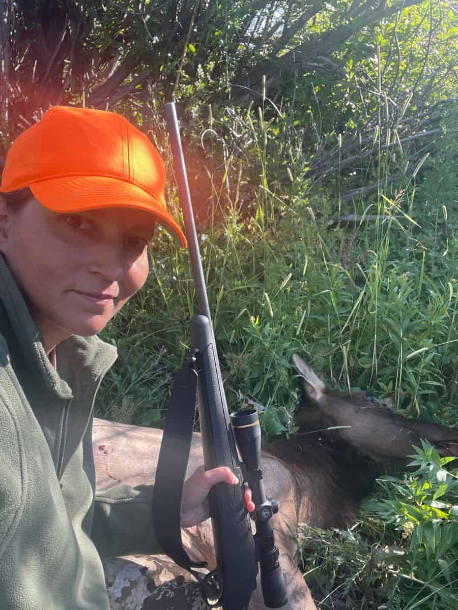 woman with elk holding rifle