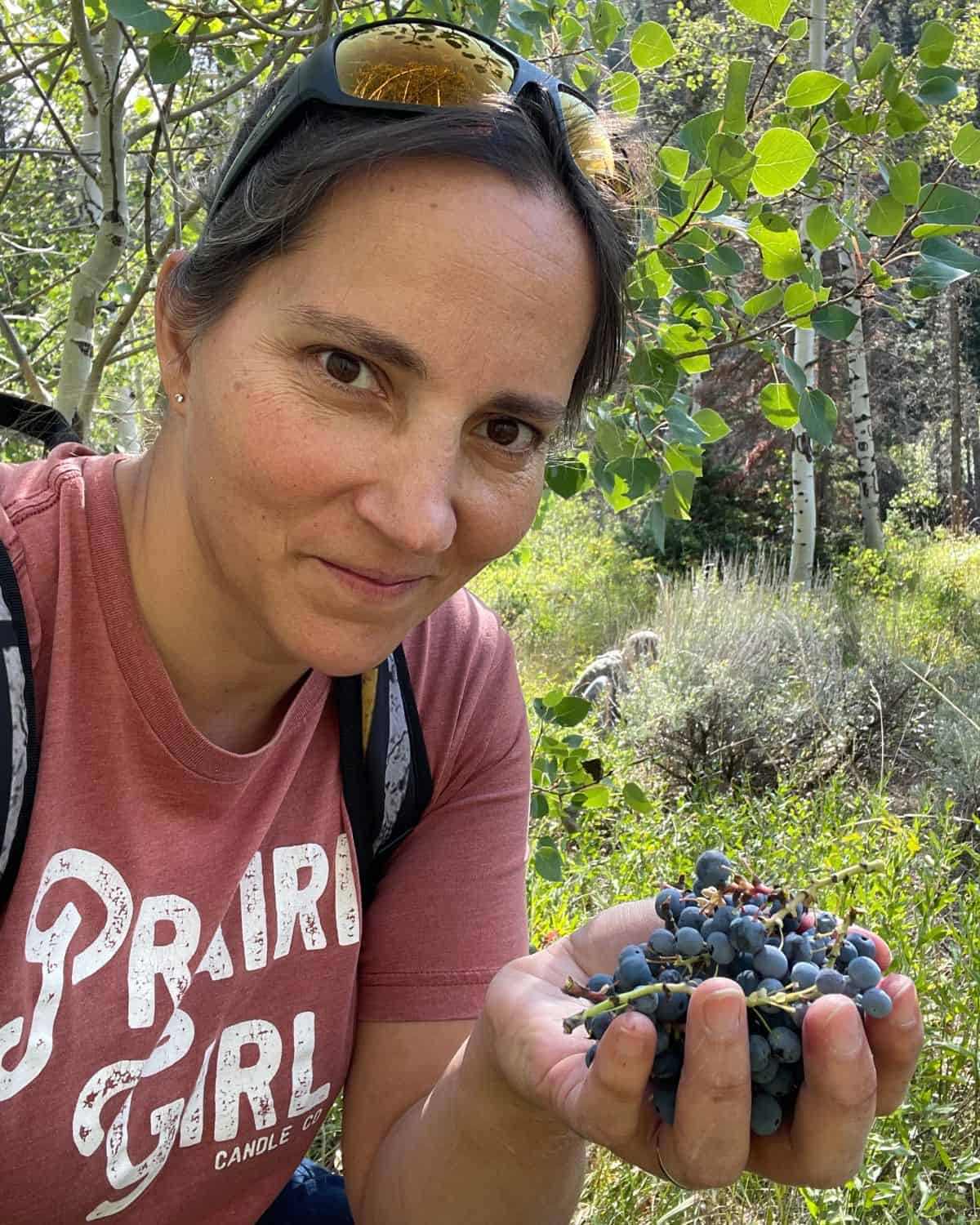 woman holding handful of Oregon Grapes 