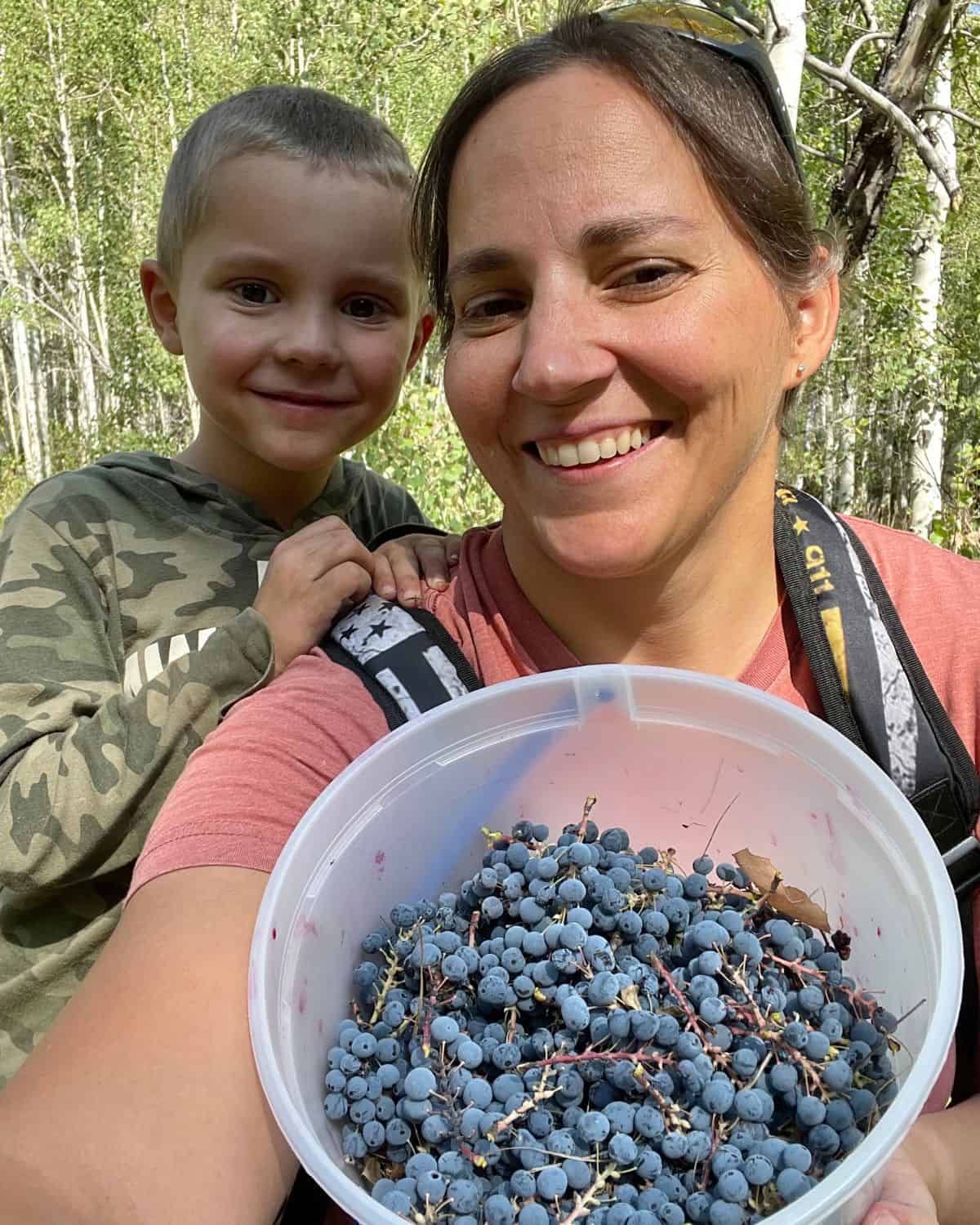 mother and child smiling with bucket of berries