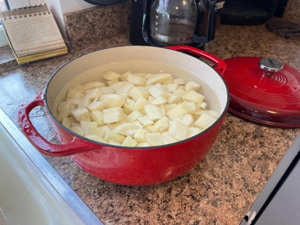 peeled and diced potatoes in red dutch oven