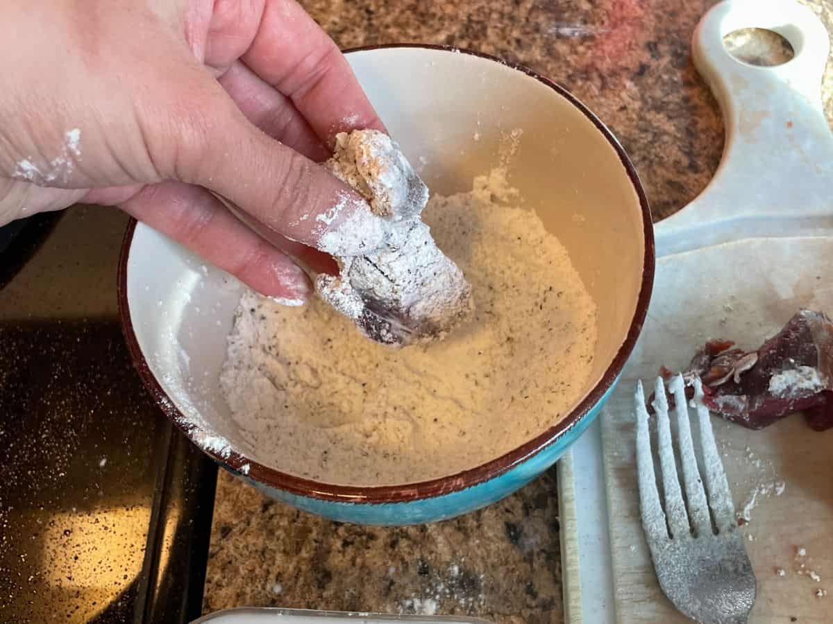 steak bites being dipped into flour mixture