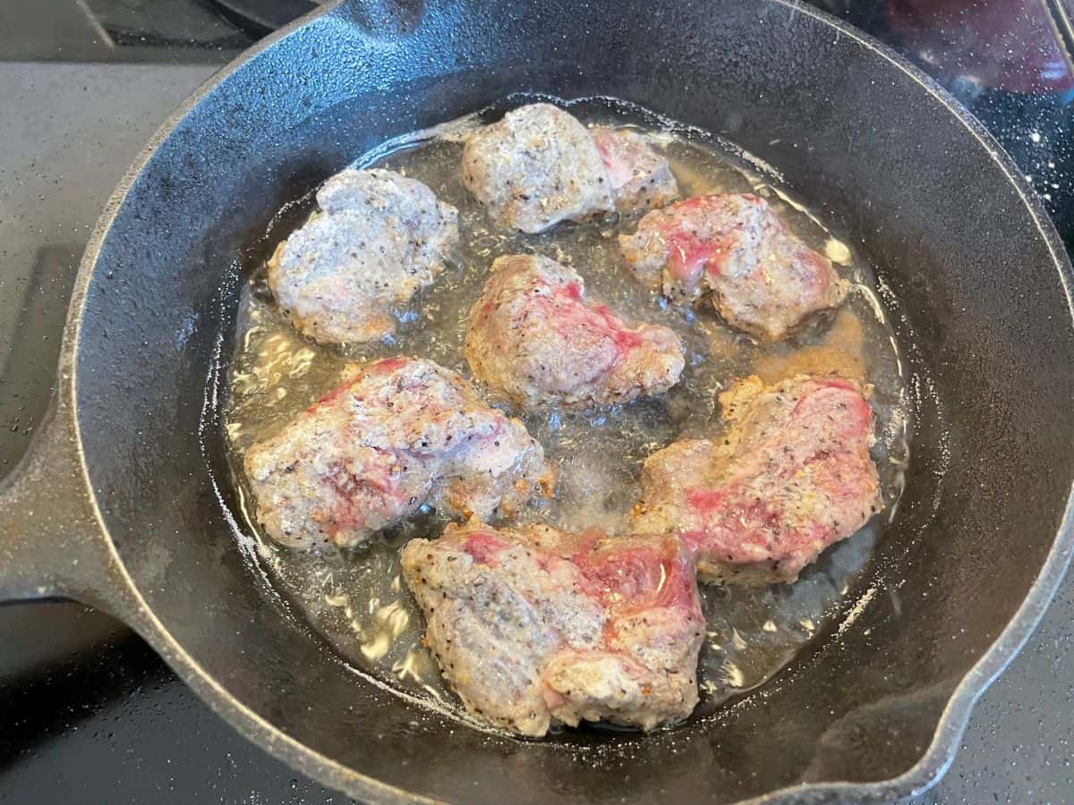 deer meat frying in cast iron